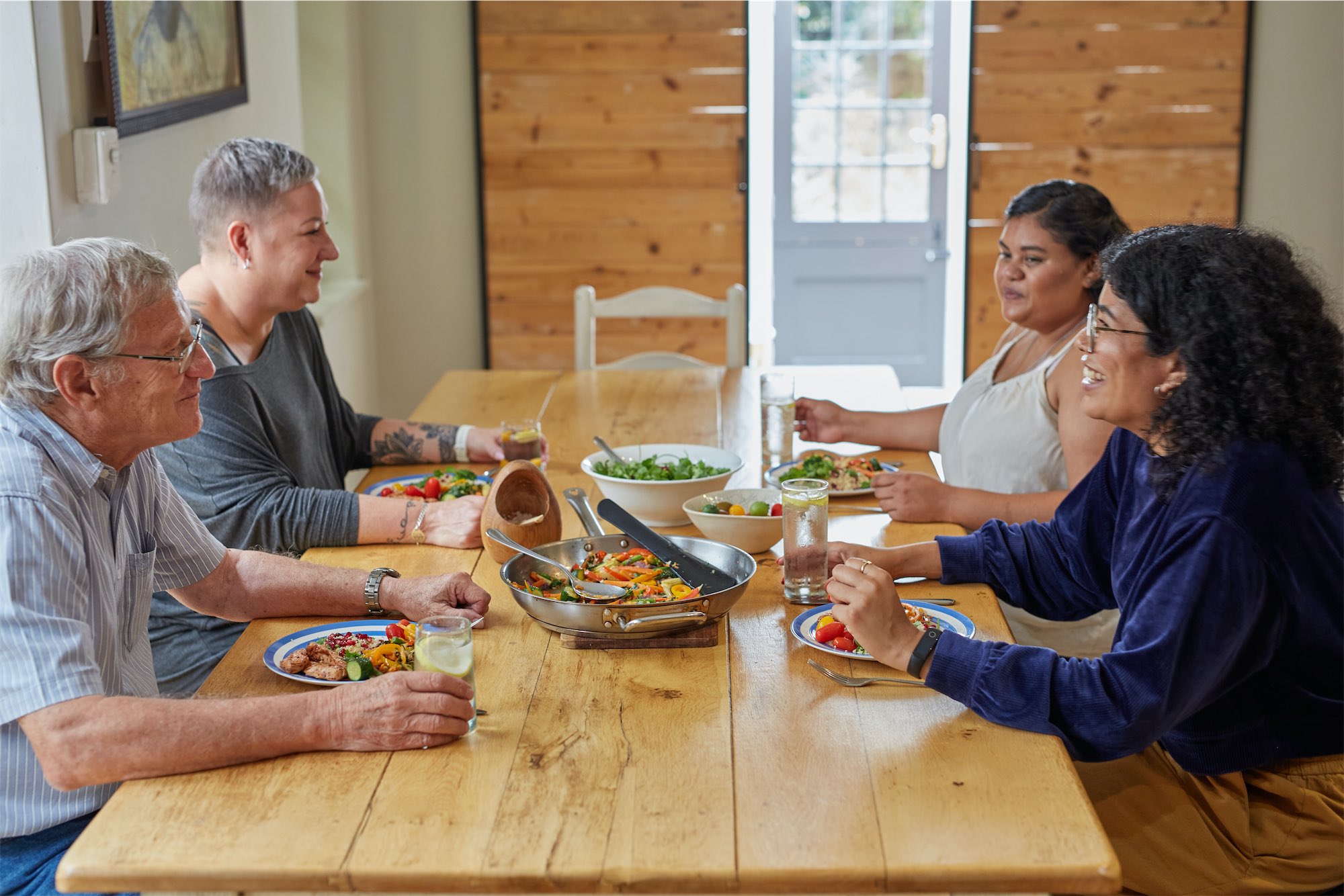 Guests and volunteers sharing a meal at the dining table