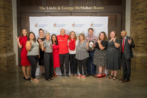 Ronald McDonald House Southwest staff and supporters gather for a group photo in the Linda and George McMahan Room