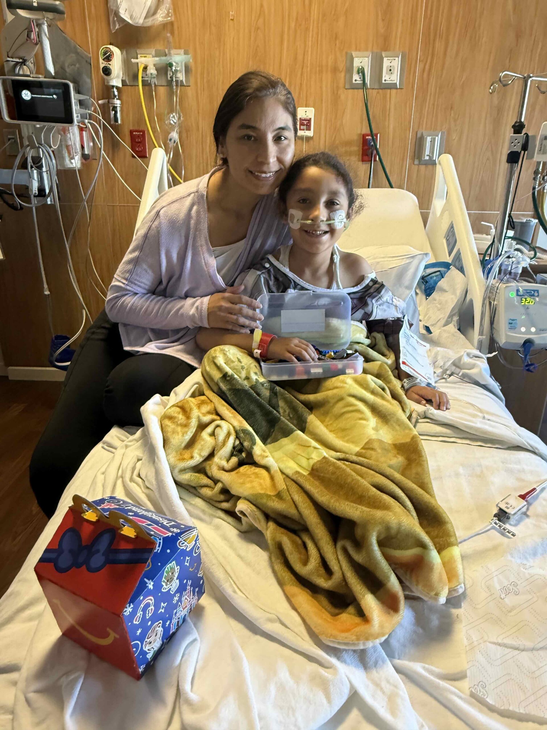 A mother sitting with her daughter in a hospital room